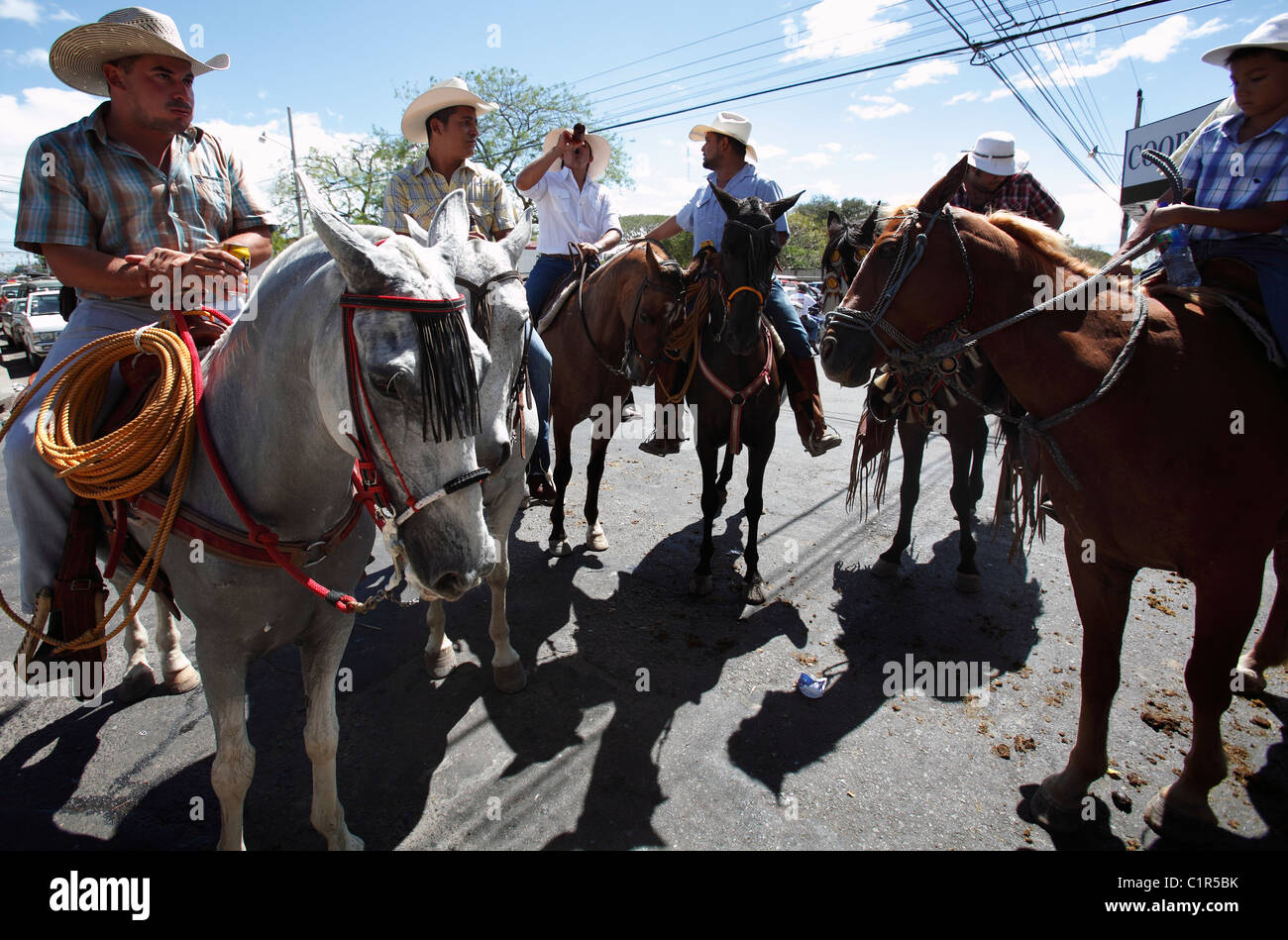 Costa Rica des hommes à cheval de boire de la bière après avoir participé à un défilé de chevaux au cours d'une fête civique au Liberia, Costa Rica Banque D'Images