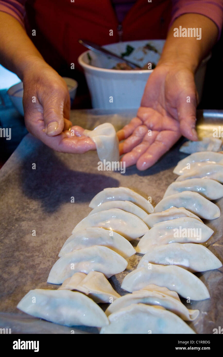 Cuisinier chinois démontrant comment faire de wor tip, également connu sous le nom de boulettes de porc ou potstickers Banque D'Images