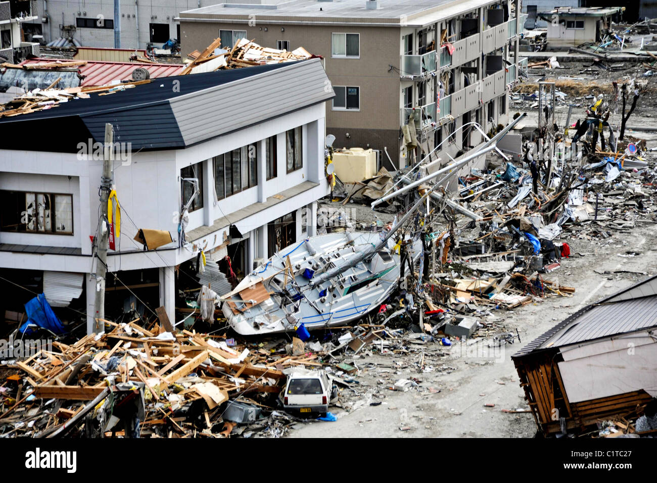 Un bateau de pêche est nettement hors de l'endroit après avoir été balayé à terre au cours d'un gigantesque tsunami qui a frappé cette pêche japonais Banque D'Images