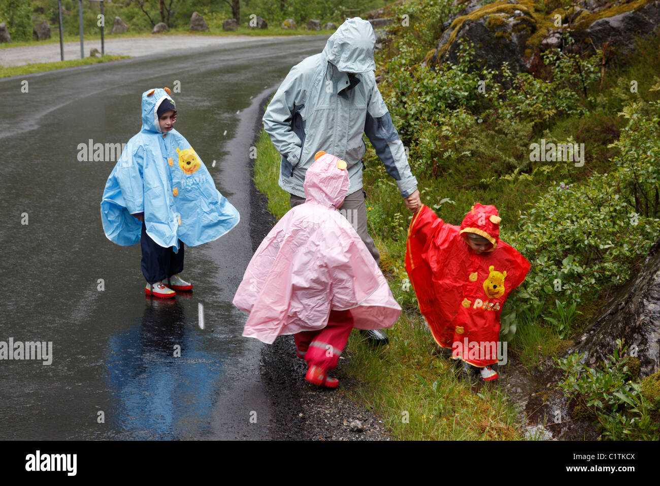 Famille avec la pluie couvre Banque D'Images