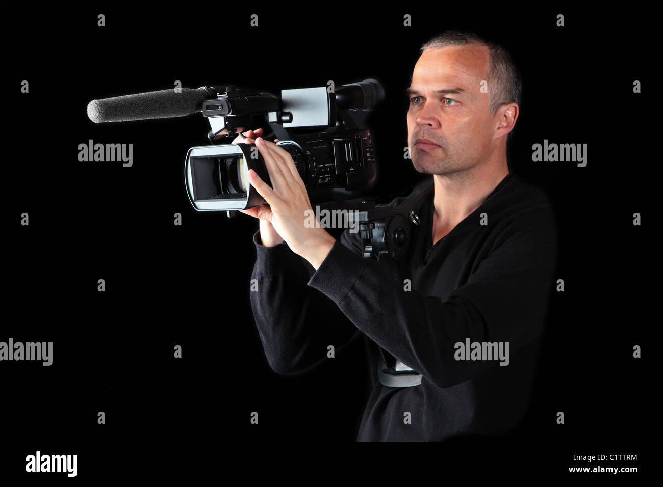 Vidéographe mâle monté son épaule points caméra vidéo et films dans la nuit Banque D'Images