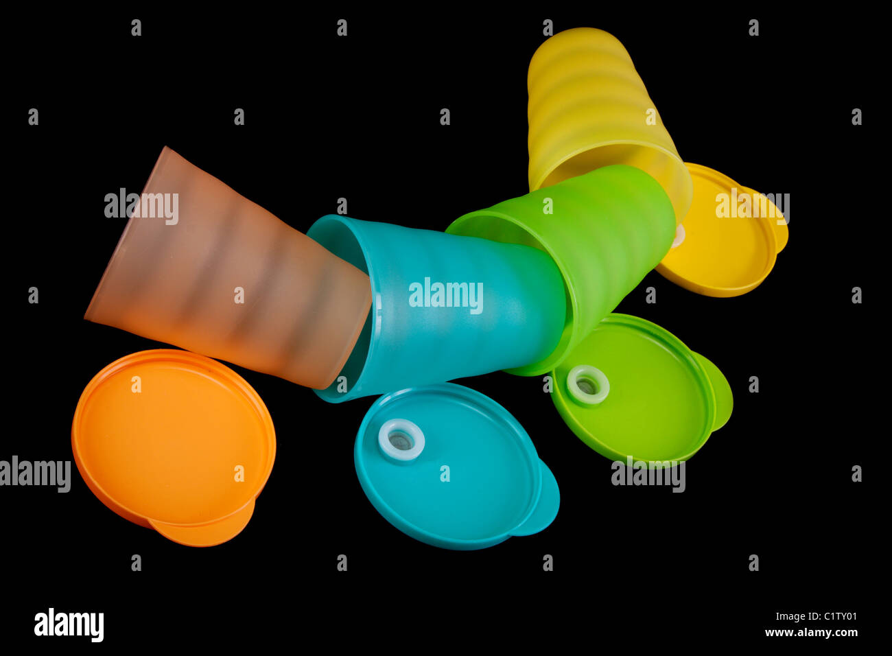 Verres en plastique de couleur se trouve dans la rangée sur fond noir Banque D'Images