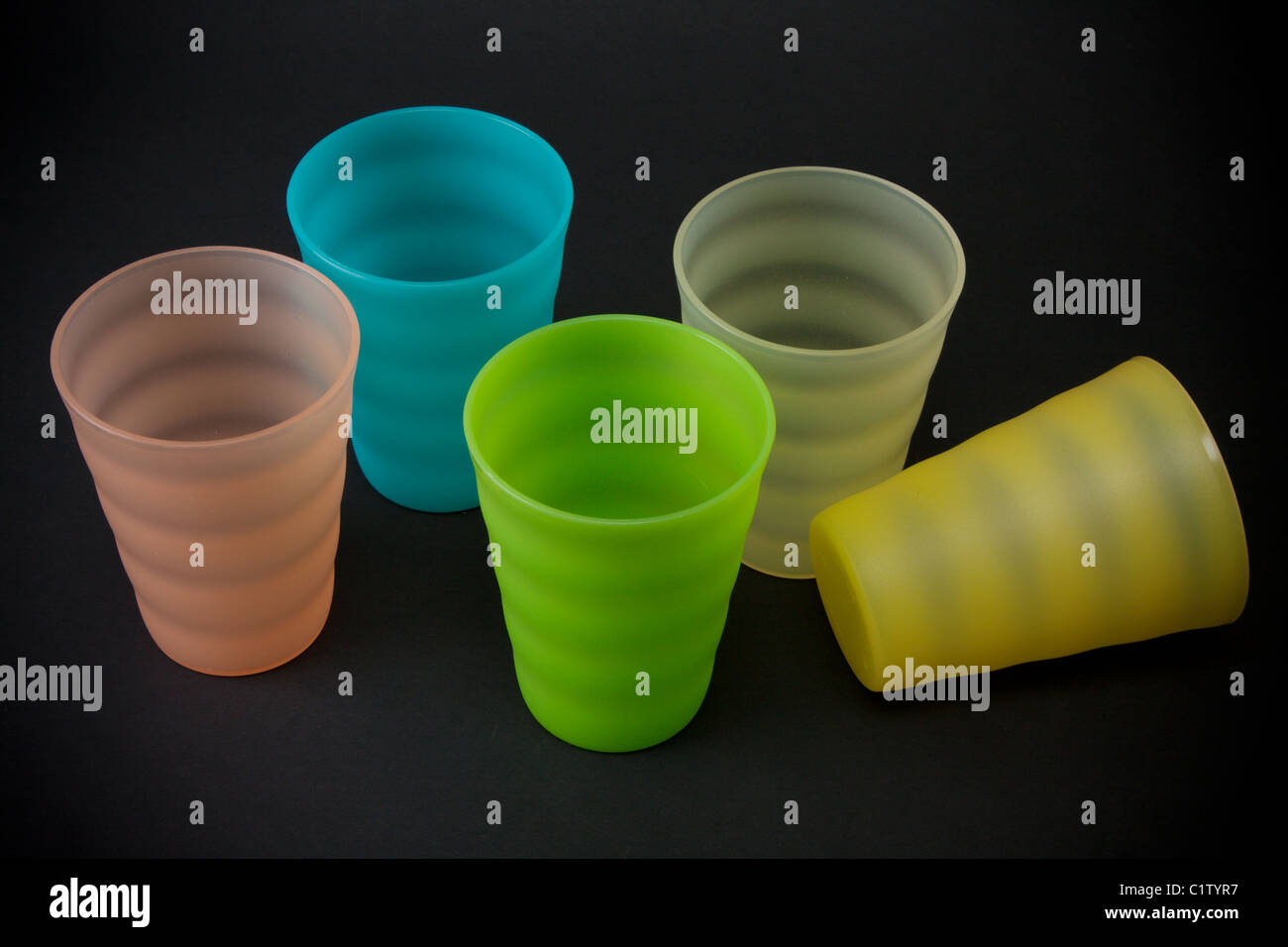 Verres en plastique de couleur sur fond sombre Banque D'Images