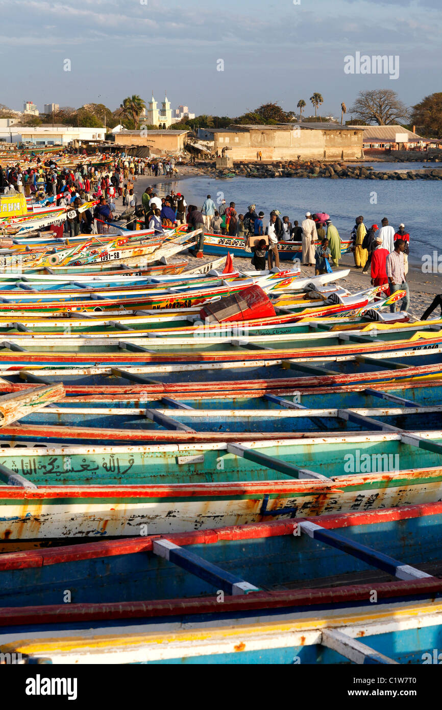 Bateaux de pêche peintes de couleurs vives bordent la plage du marché aux poissons de Dakar, Sénégal Banque D'Images
