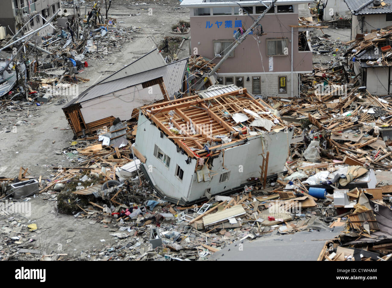Une maison se trouve à l'envers sur son toit parmi des débris dans Ofunato, Japon, après le séisme de mars 2011  + tsunami. Banque D'Images