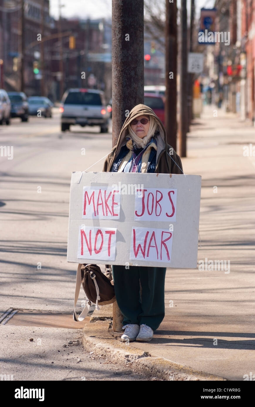 A 68 ans, femme de Pittsburgh se dresse sur la rue avant une manifestation anti-guerre à Pittsburgh, PA. Banque D'Images