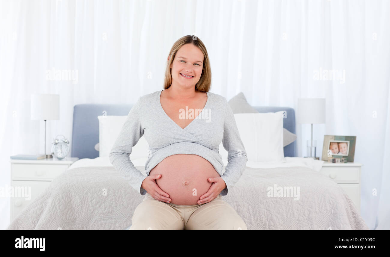Joyfull femme enceinte dans sa chambre à coucher Banque D'Images
