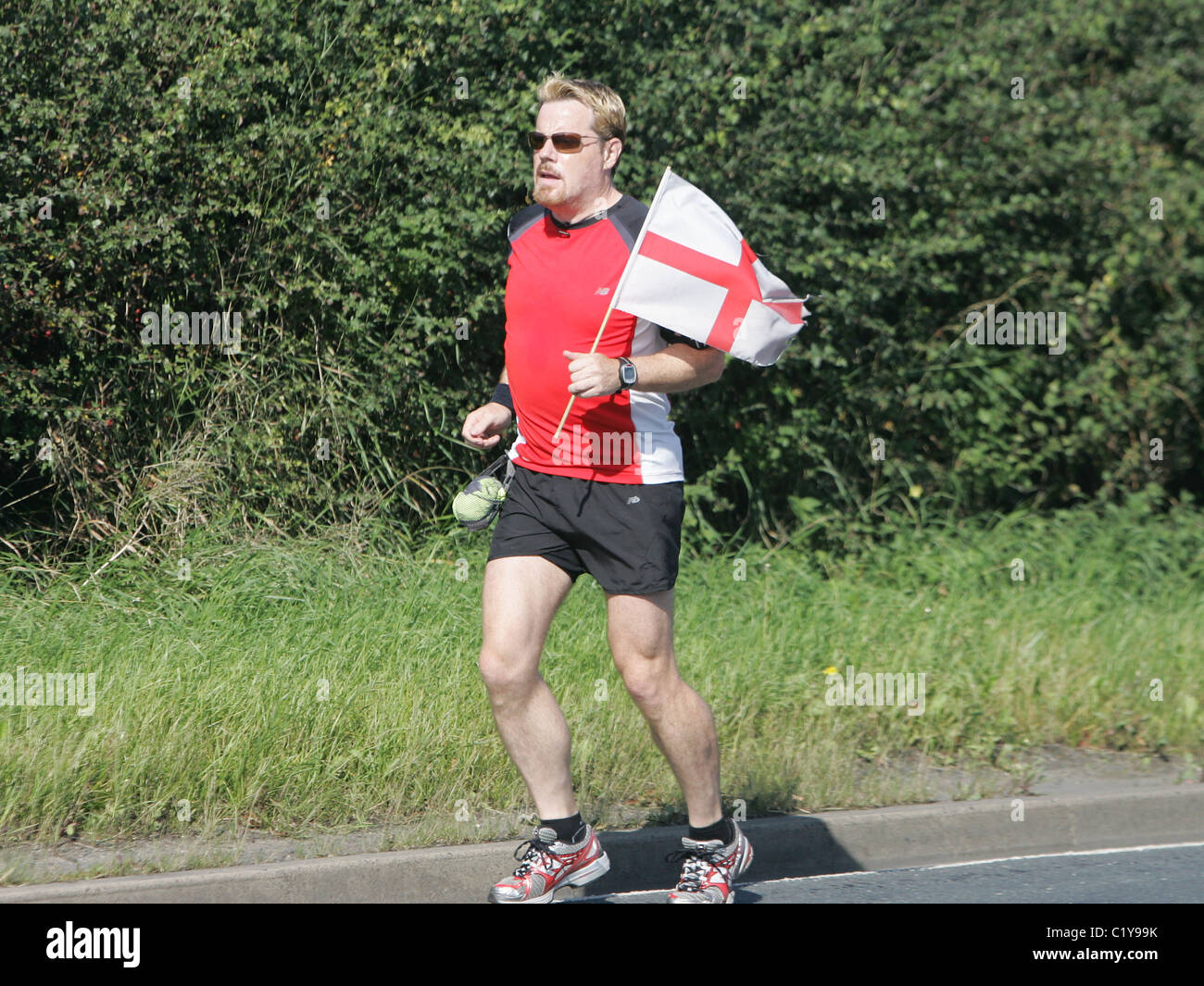 Eddie Izzard continue sur son marathon 24 défi comme il fait son chemin à travers de Harrogate Leeds dans l'aide de secours Sport Banque D'Images