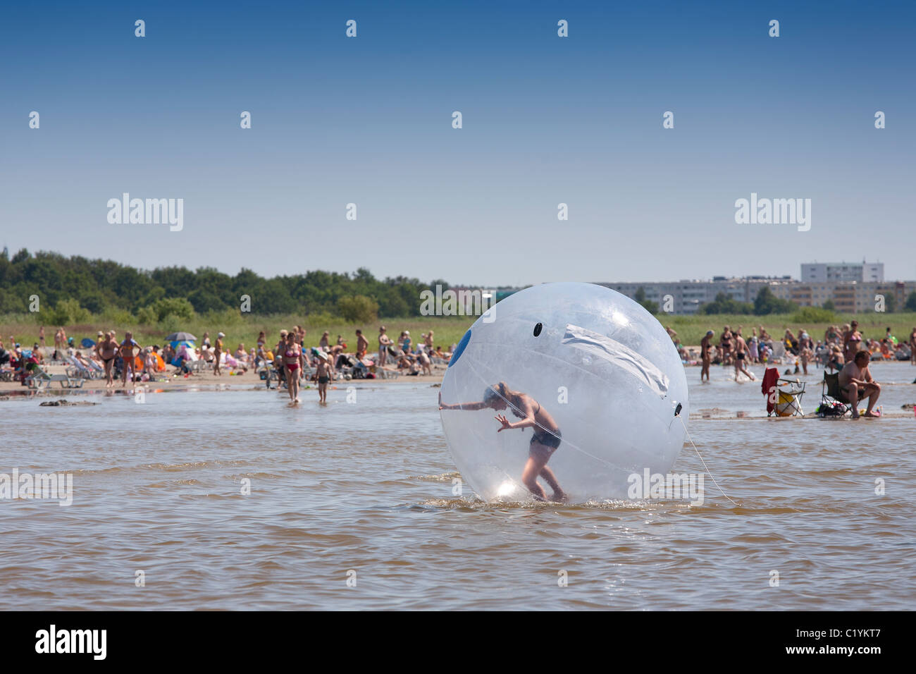 Gosse sur la plage de Pärnu dans big ball gonflable, Estonie Banque D'Images