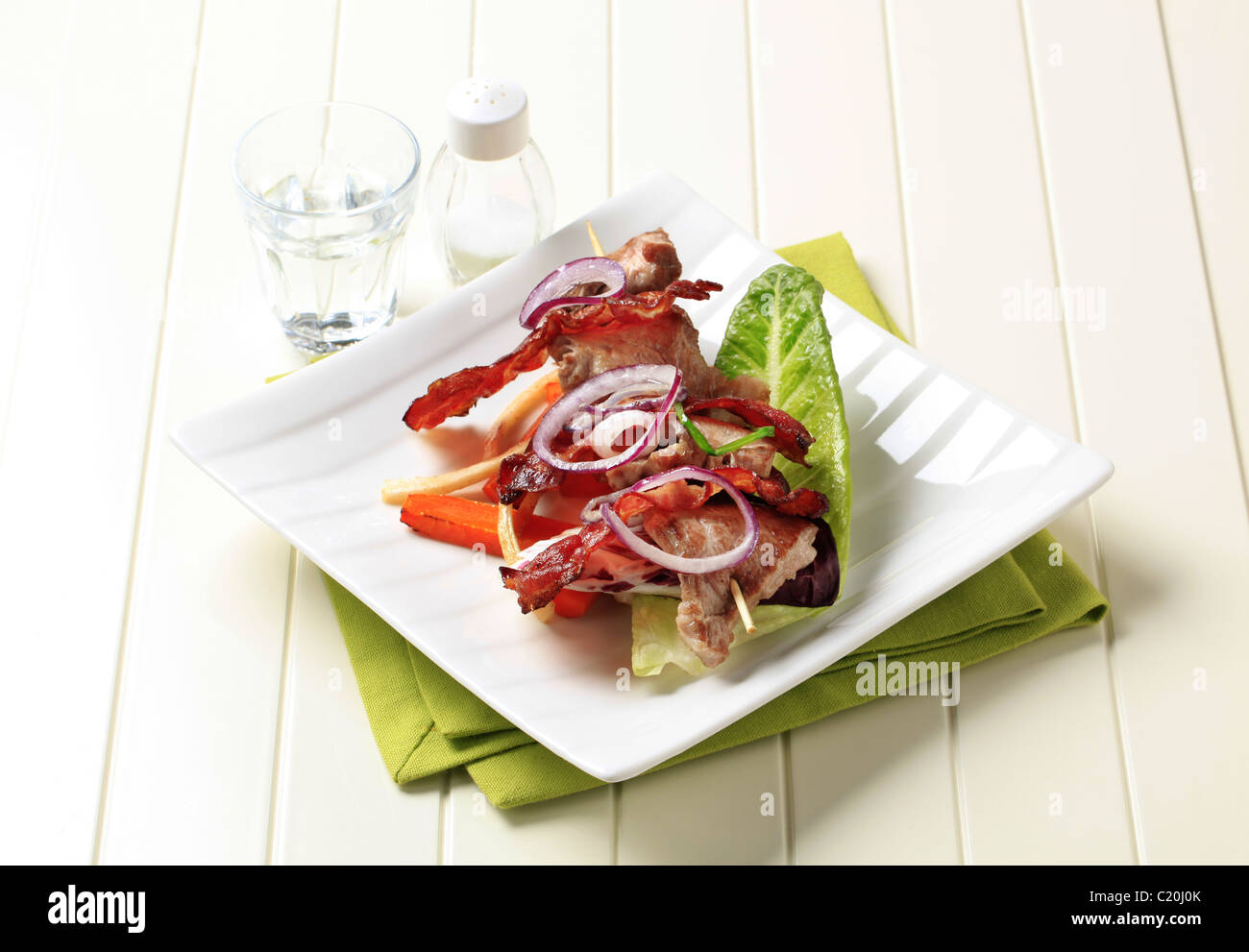 Shish kebab avec des tranches de bacon croustillant et légumes rôtis Banque D'Images