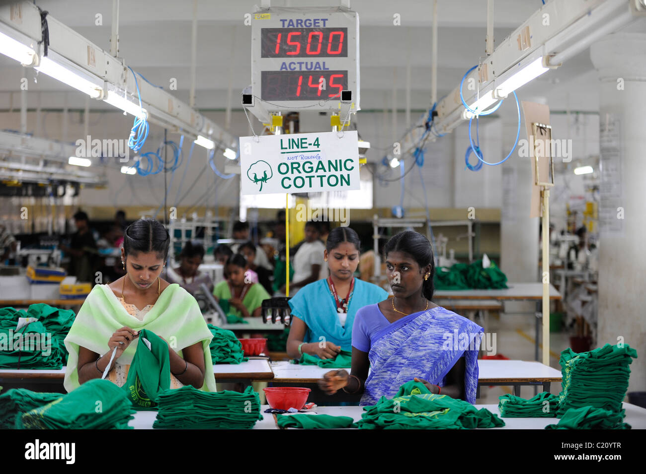 L'Inde, Tamil Nadu, Chennai , femmes travaillent dans l'usine textile du commerce équitable, de la production de T-shirt vert avec le slogan imprimé Penser vert Banque D'Images