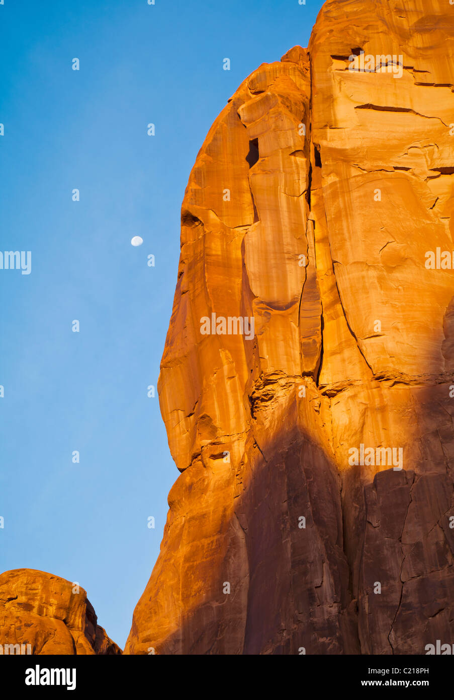 Lune et de falaises de grès avec la lune dans un ciel bleu, Arches National Park, Utah, USA. Banque D'Images