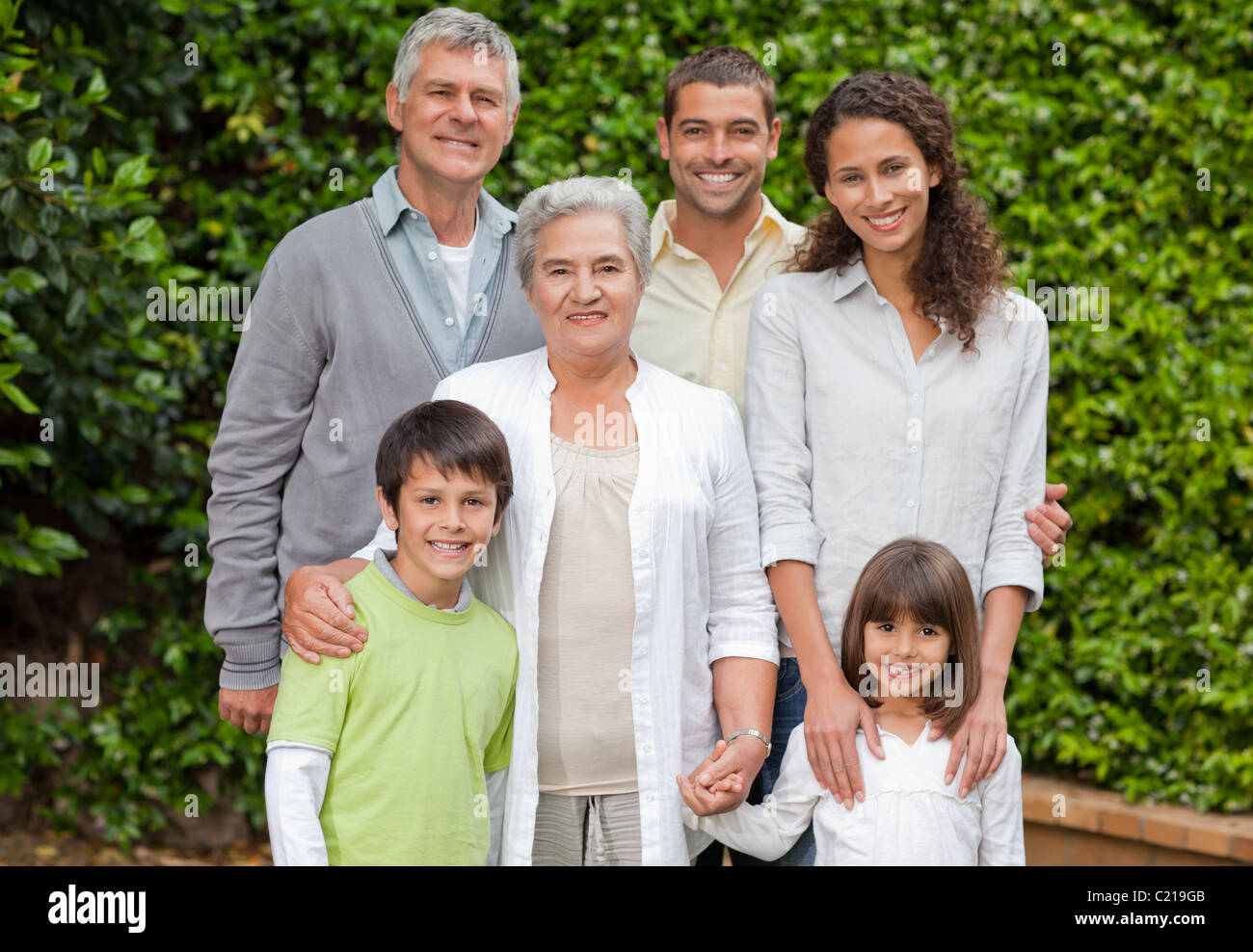 Portrait d'une famille heureuse regardant la caméra dans le jardin Banque D'Images