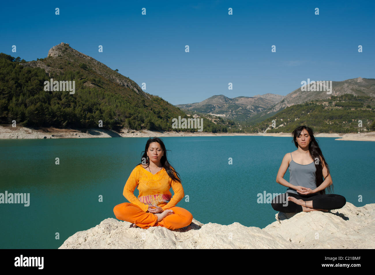 Mère et fille, du yoga à la belle au bord du lac Banque D'Images