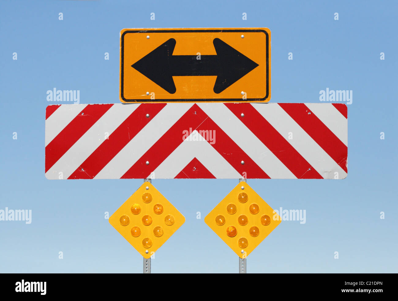 Flèche à double face et à l'image des panneaux d'avertissement à un carrefour en T sur une route Banque D'Images