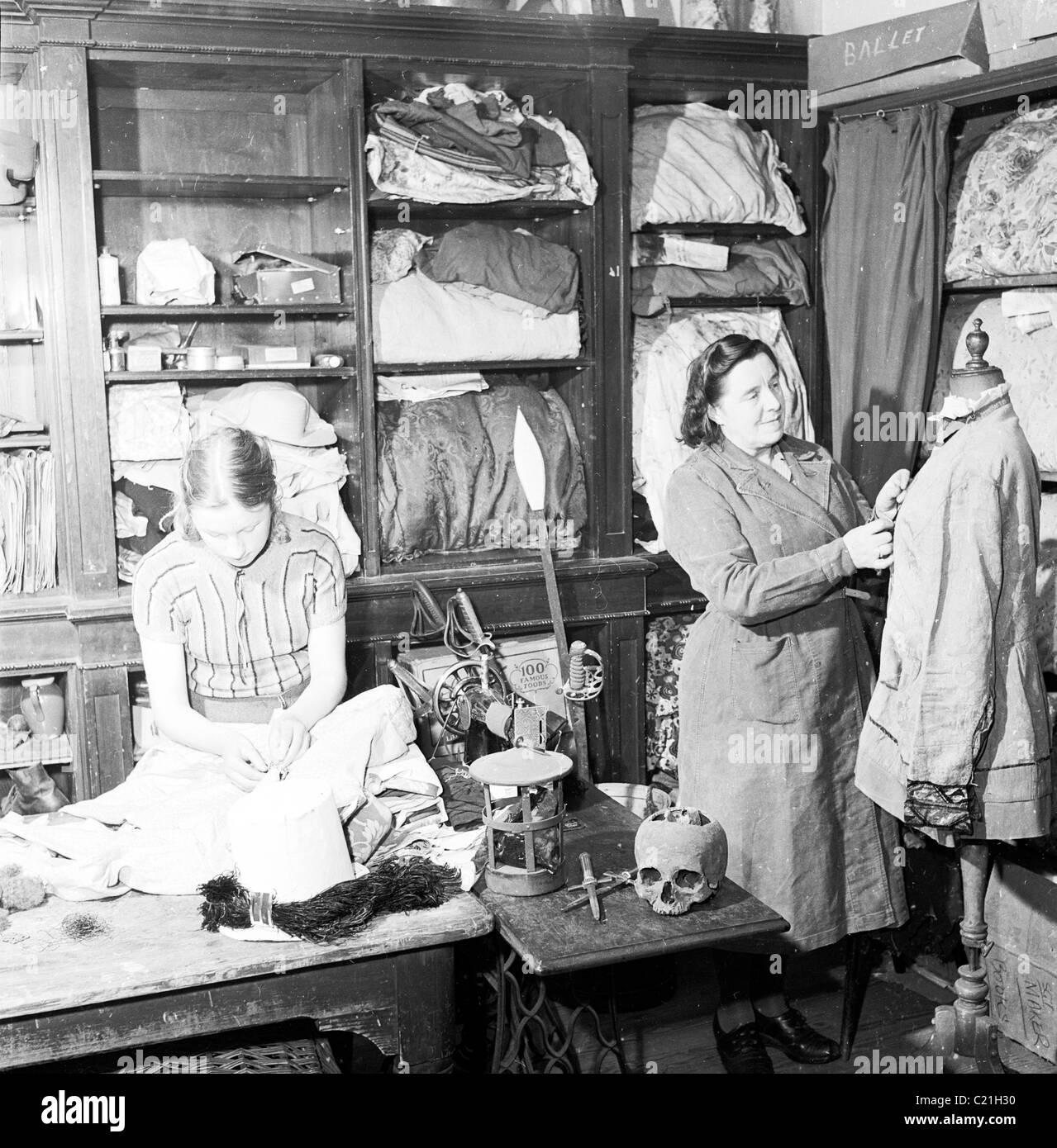 Années 1950, historique, à l'intérieur d'un département de costumes, une femme et une jeune femme travaillant sur des vêtements de théâtre dans cette photo de J Allan Cash. Banque D'Images