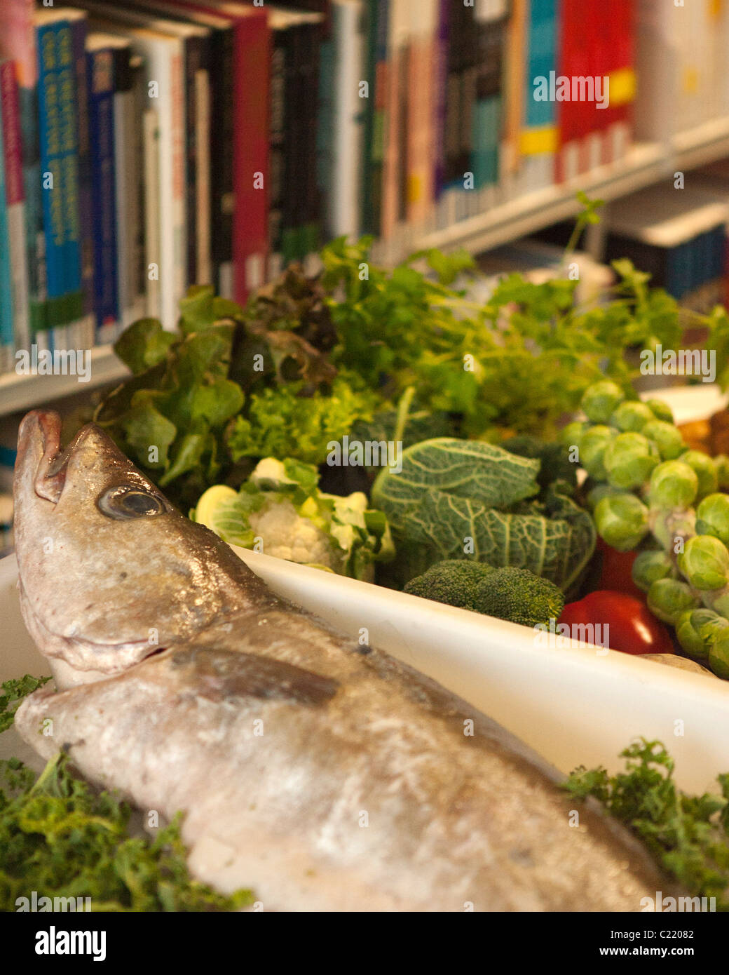 UK - l'Ecosse -- 2011. Pollock, le poisson avec légumes de saison dans une bibliothèque de livres de cuisine. Photo : © Russell Sneddon Banque D'Images