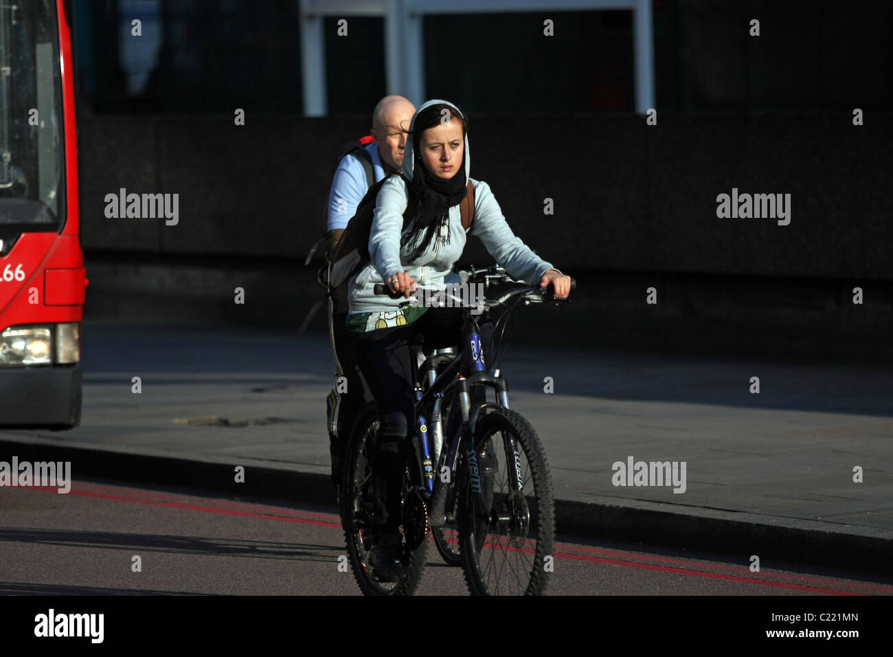 Un dépassement cycliste féminin masculin un cycliste à Londres, en  Angleterre, par un après-midi ensoleillé Photo Stock - Alamy