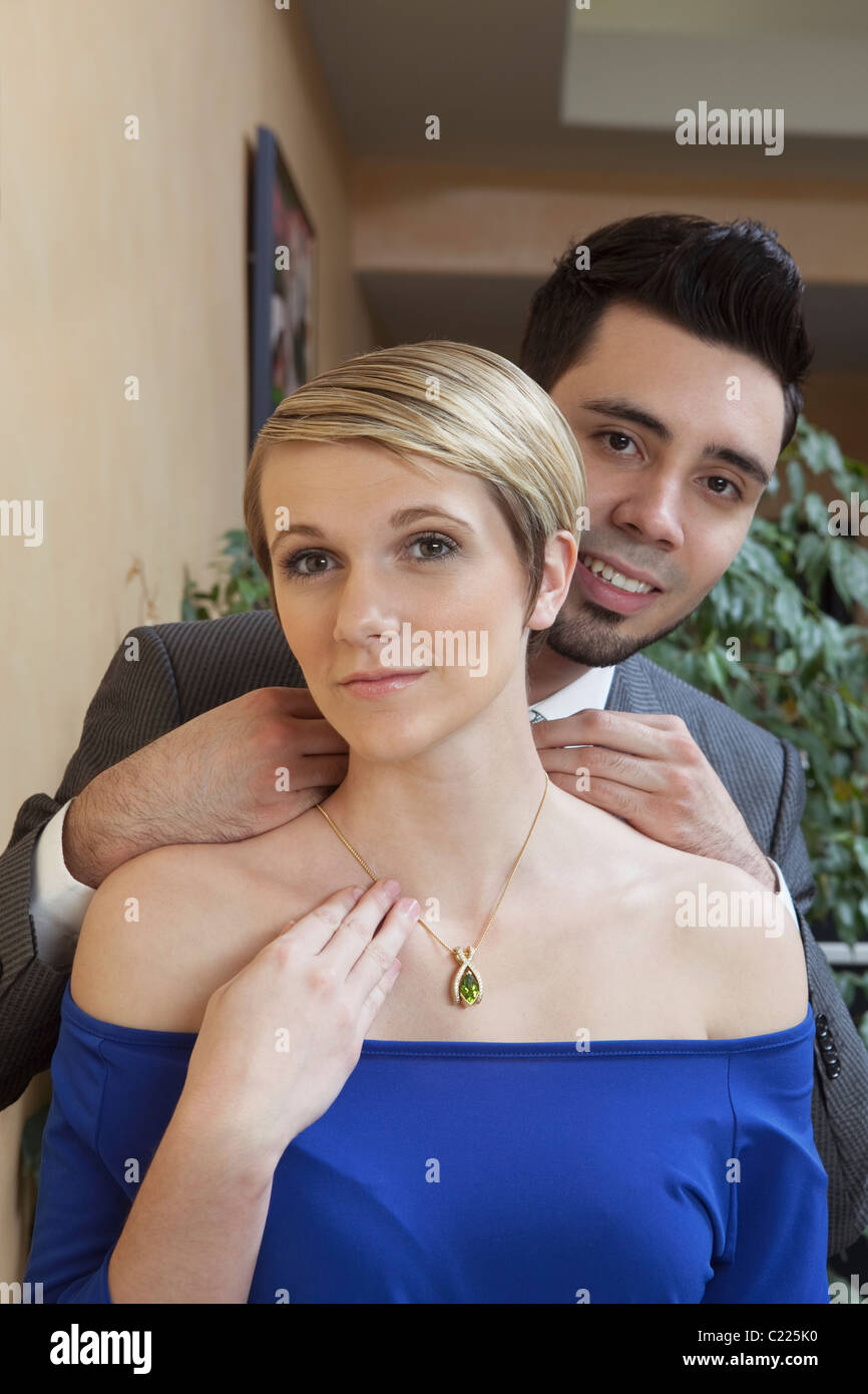 Un couple dans un magasin de bijoux de luxe:où l'homme est maintenant un collier exclusif autour du cou chez les femmes Banque D'Images