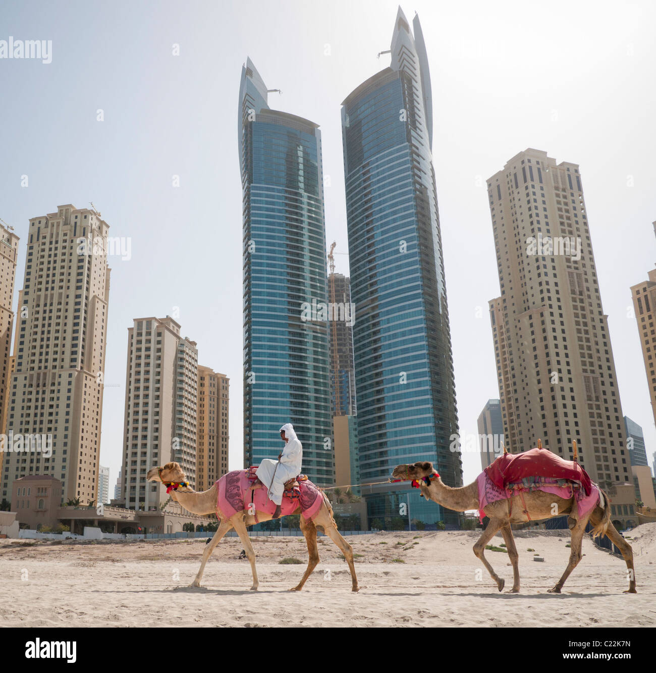 Un homme monté sur un chameau sur la plage à Dubaï aux Émirats arabes unis Banque D'Images