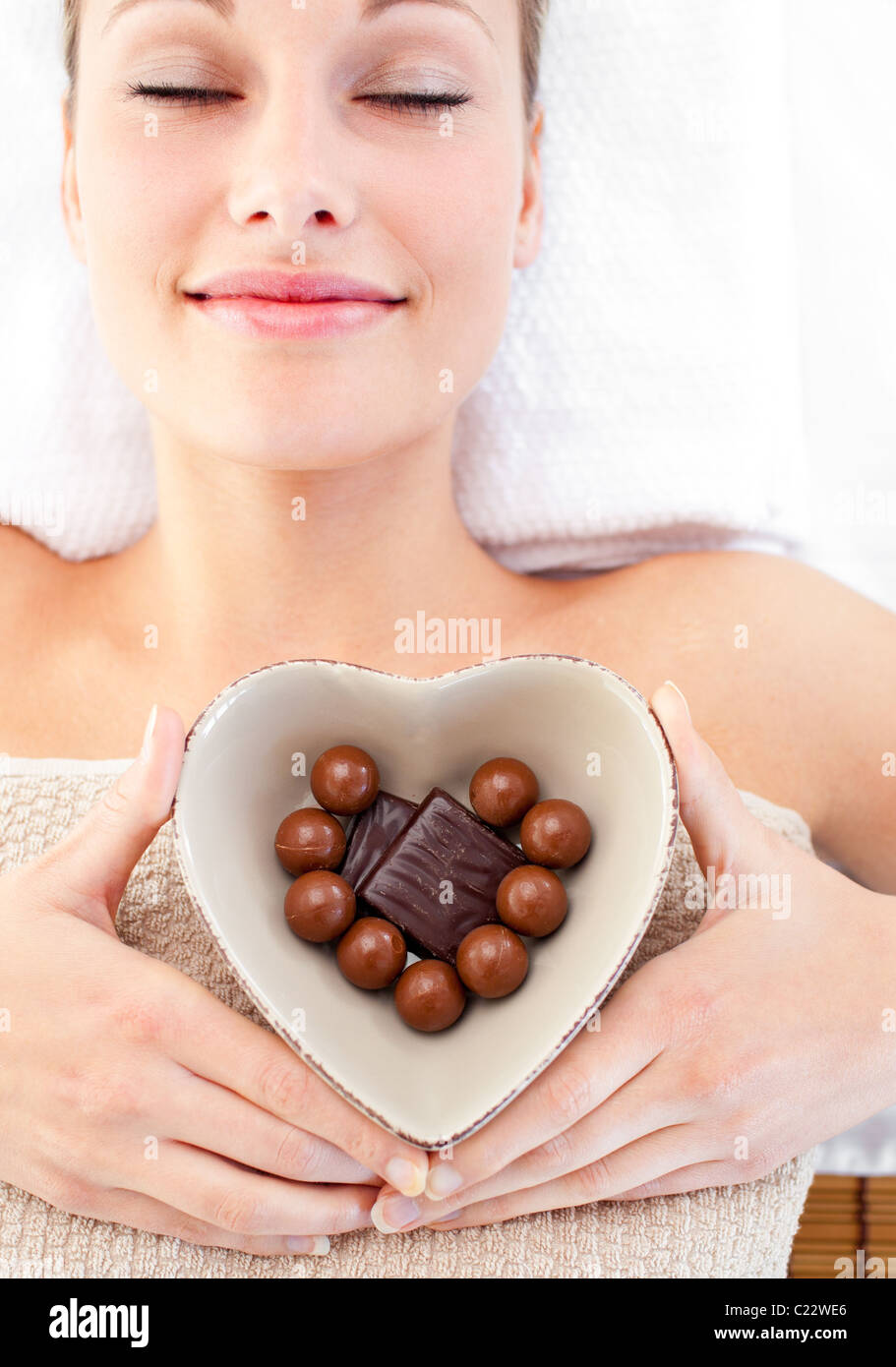 Femme tenant un bol lumineux en forme de cœur avec du chocolat Banque D'Images