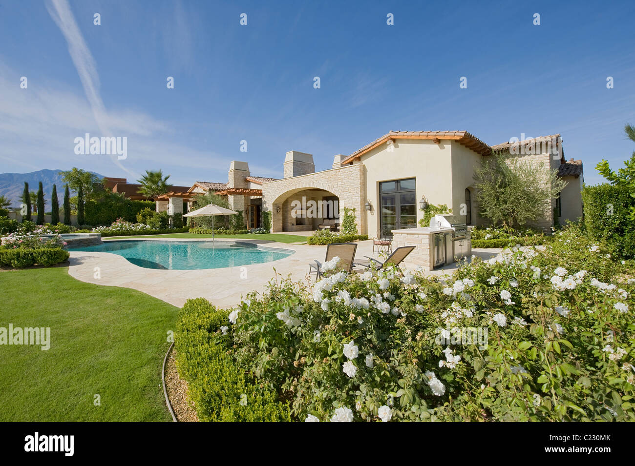 À la lumière du jour extérieur de maison avec un jardin des Plantes::une piscine et les collines au loin Banque D'Images