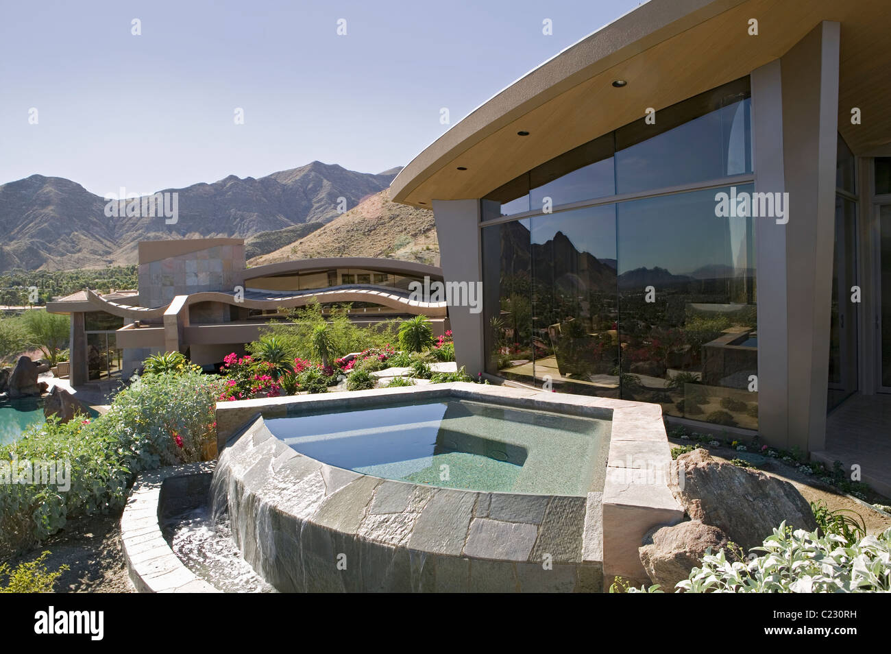 Extérieur d'une maison moderne avec une petite piscine et les montagnes en arrière-plan Banque D'Images