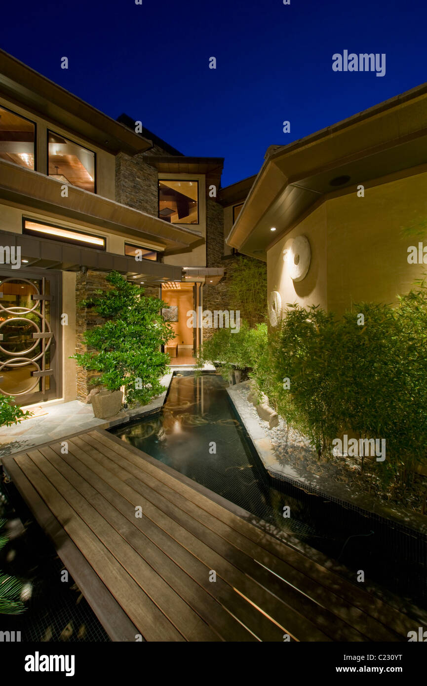 Nuit à l'extérieur de maison avec passerelle en bois au-dessus de l'eau Banque D'Images