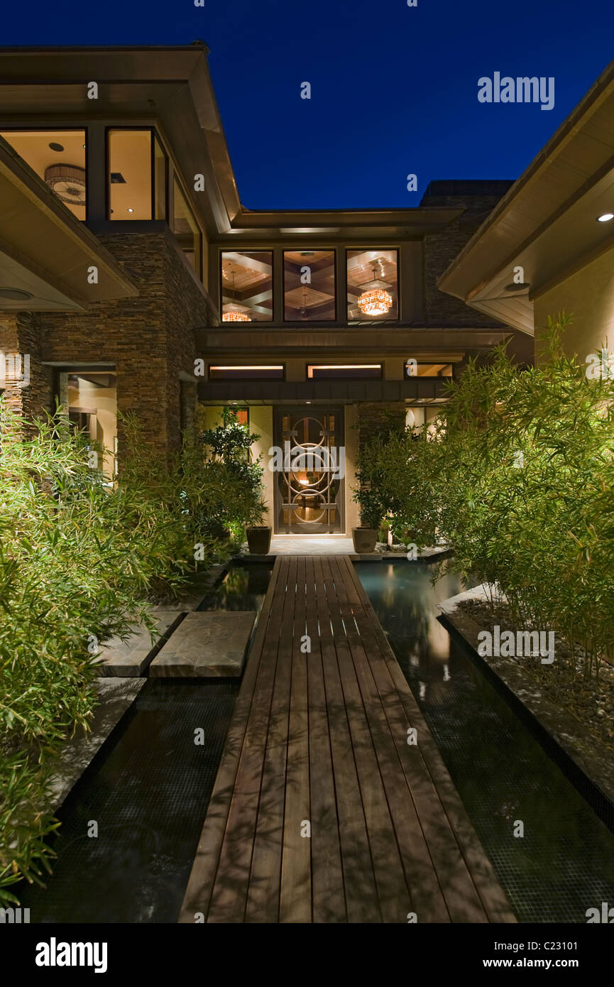 Nuit à l'extérieur de maison avec passerelle en bois au-dessus de l'eau Banque D'Images