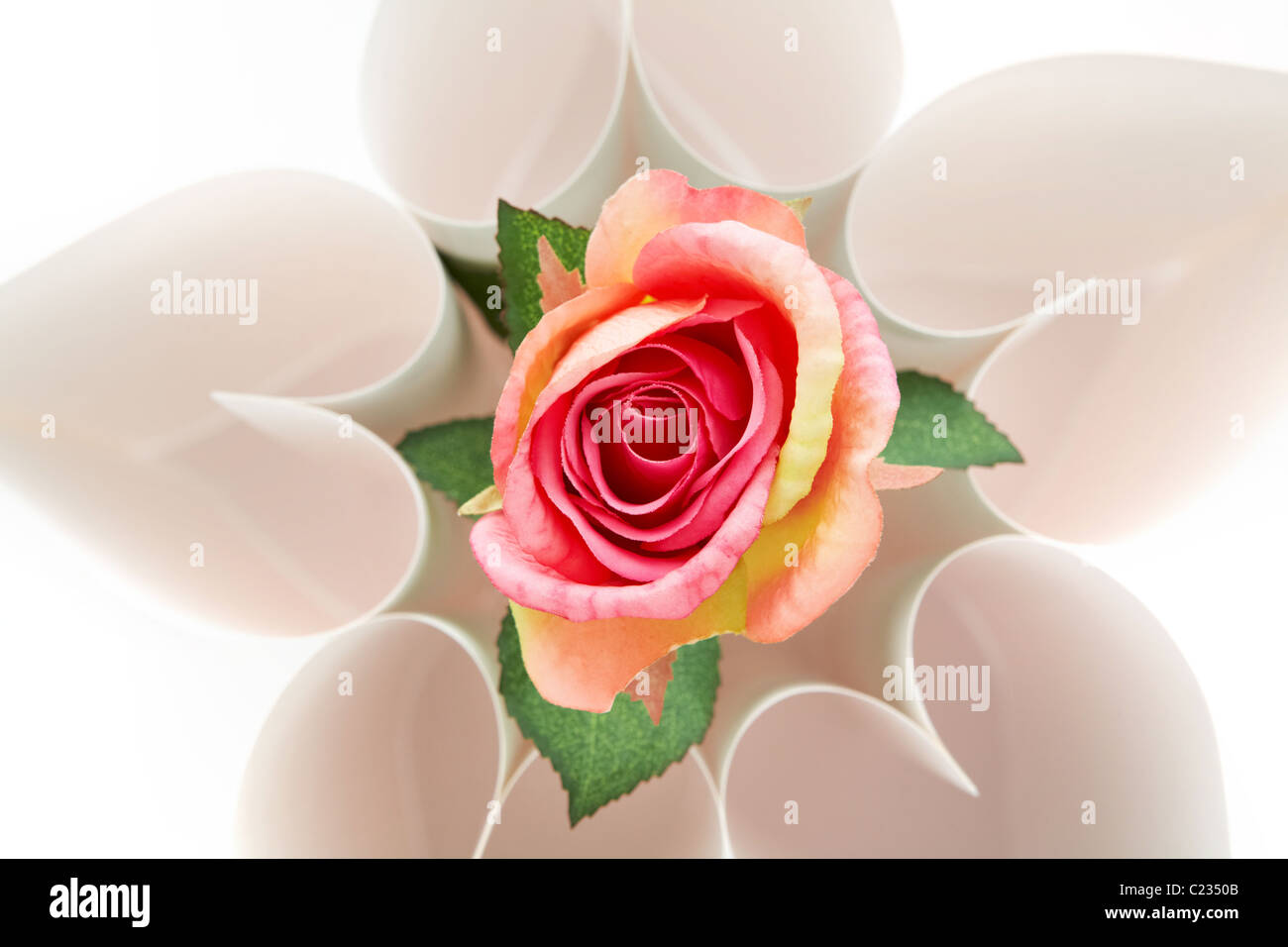 Vue de dessus de forme florale composée de coeurs avec du papier rose en son centre Banque D'Images