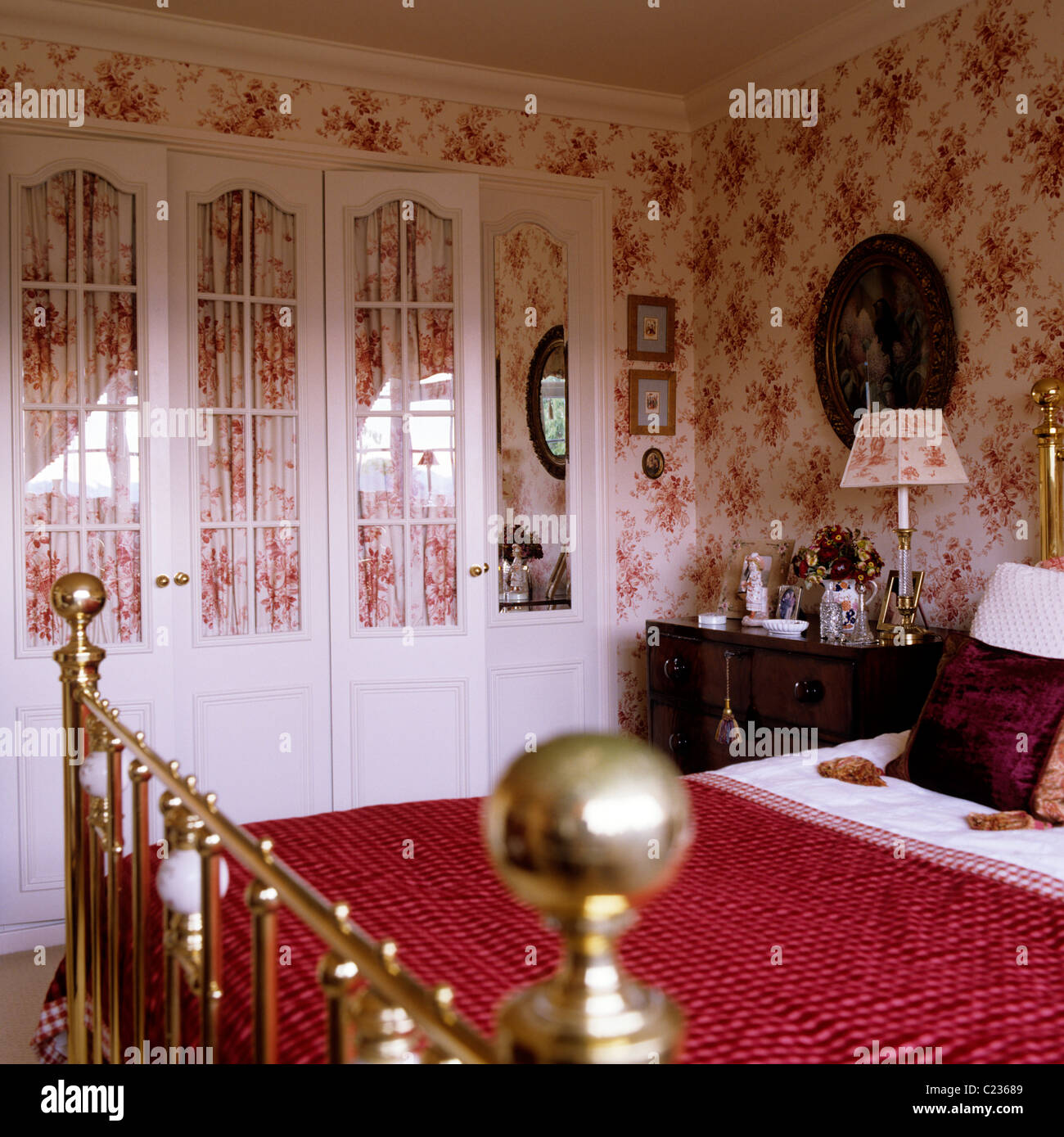 Courtepointe rouge laiton sur pans de lit dans la chambre avec toile de jouy Banque D'Images