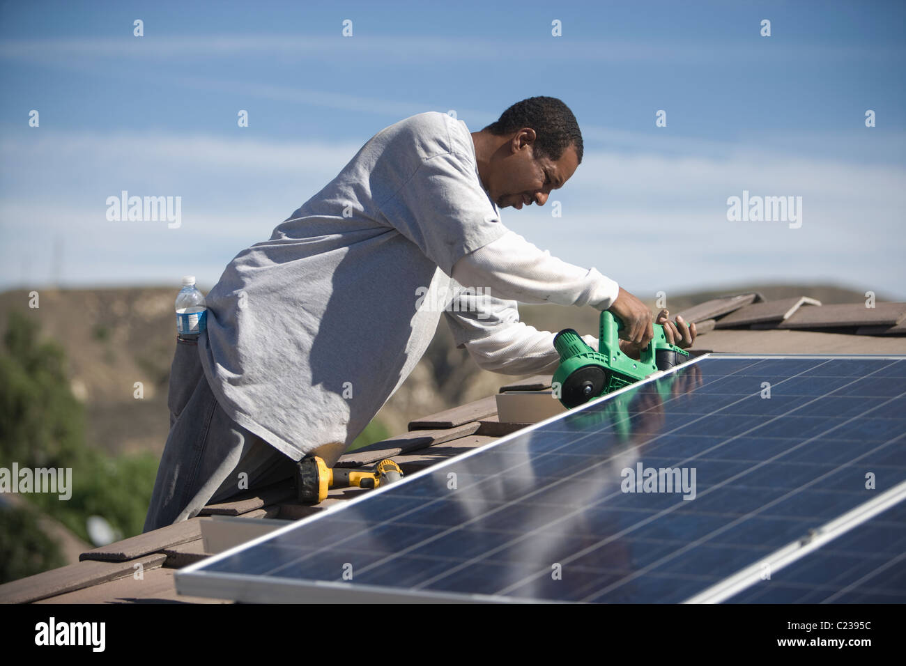 Un homme sur un toit panneaux solaires sur le travail Banque D'Images