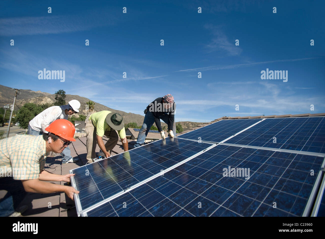 Un groupe d'hommes portant un grand panneau solaire Banque D'Images