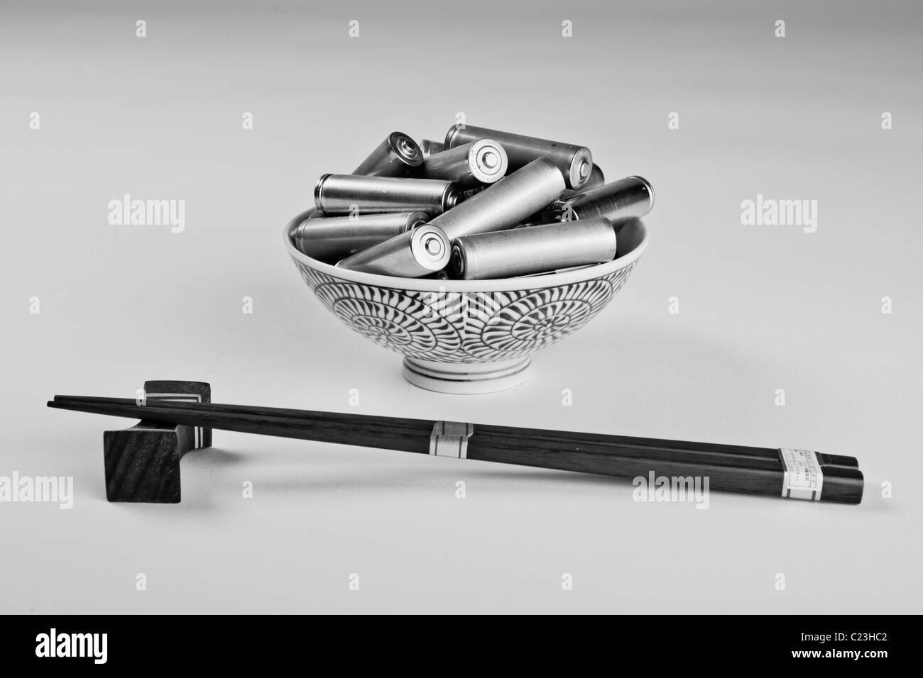 Un bol contenant des piles et de baguettes. La photo est une métaphore de la société de consommation. Banque D'Images