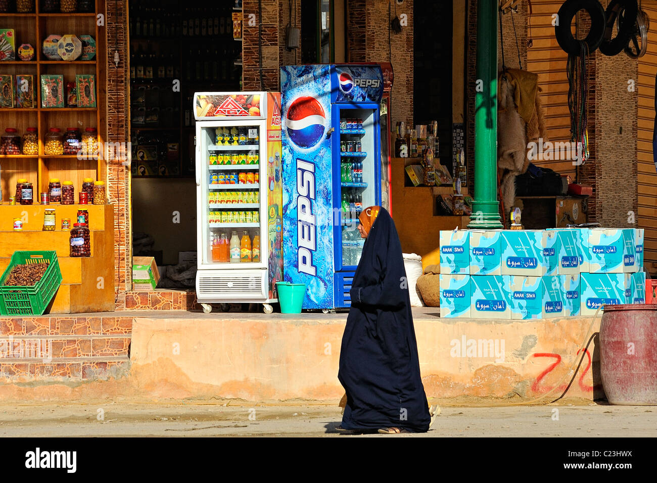 Femme égyptienne voilée marcher dans une rue de la ville de Siwa, désert de l'ouest, l'Egypte Banque D'Images