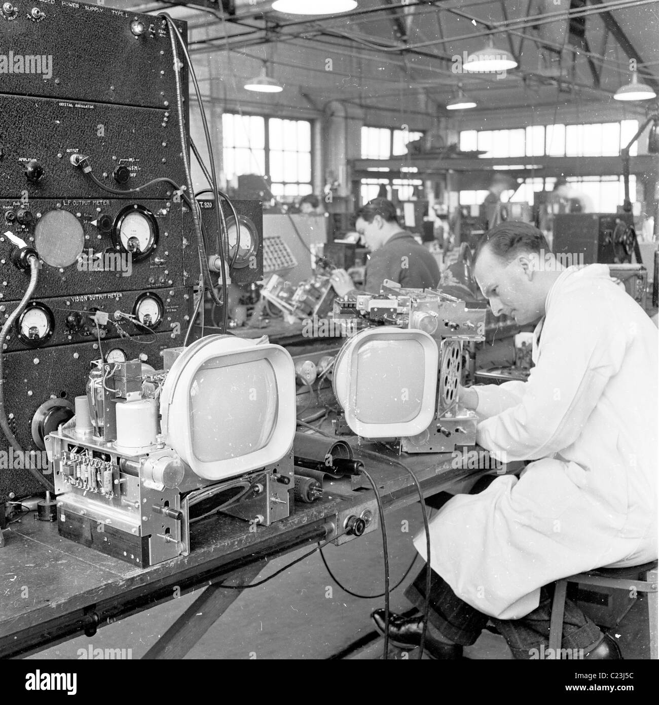 Angleterre, années 1950. Une photographie par J Allan Paiement d'une main-d'homme technicien travaillant sur la fabrication d'un poste de télévision. Banque D'Images