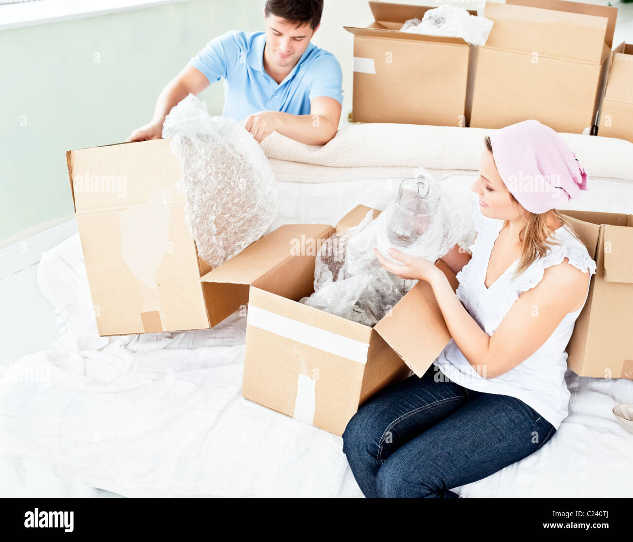 Happy young couple unpacking boxes avec des lunettes Banque D'Images