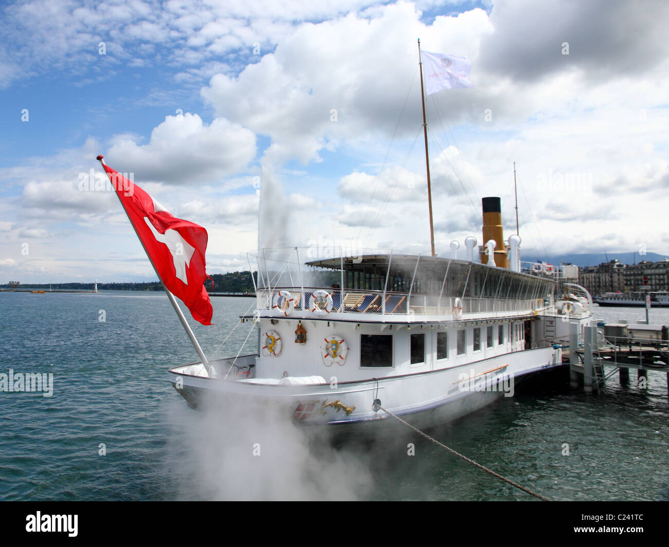 Célèbre pagayer à vapeur sur le lac Léman ancrée face à la vapeur, avec libération de Genève ville drapeau suisse Banque D'Images