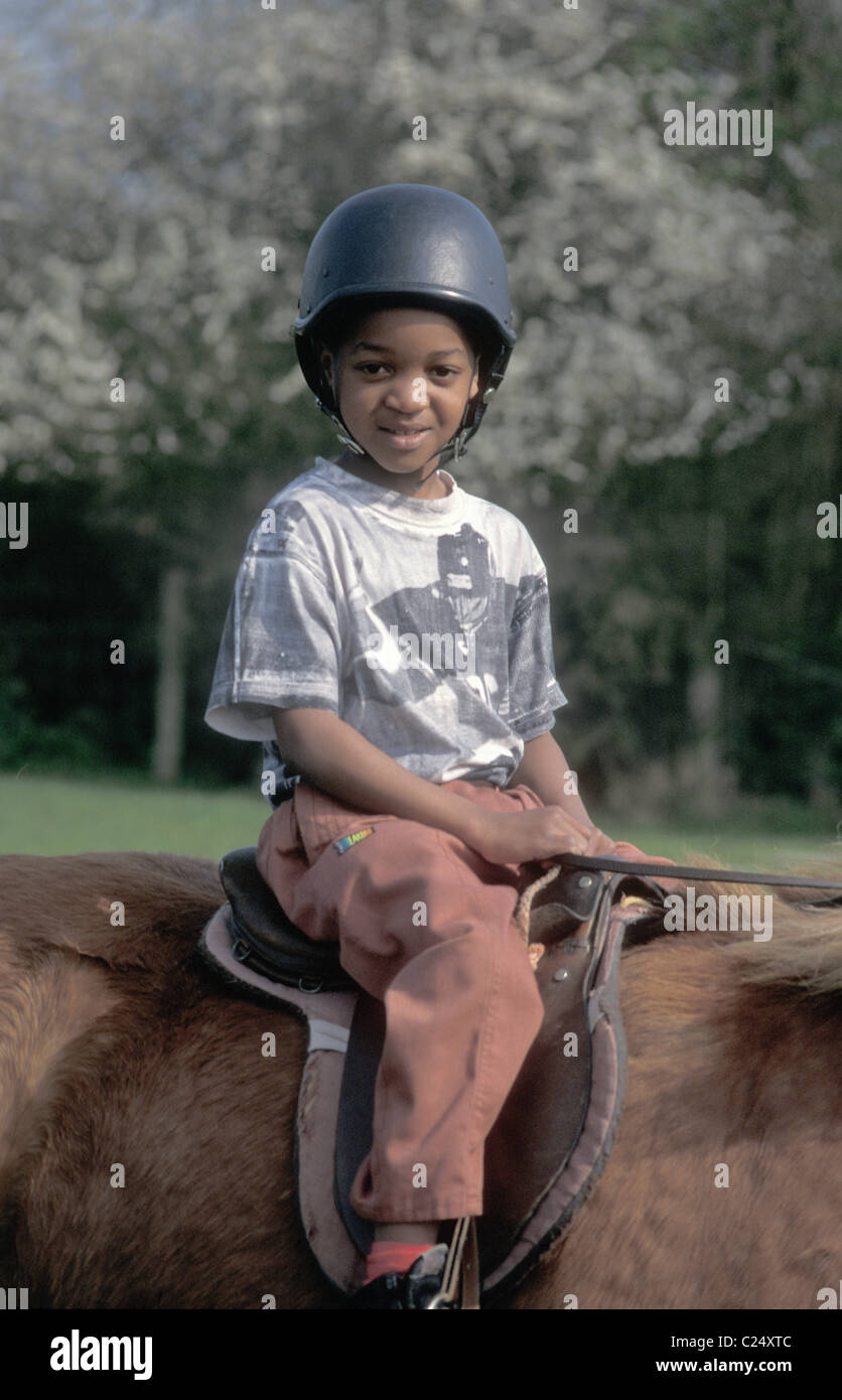 Jeune garçon noir à cheval Banque D'Images