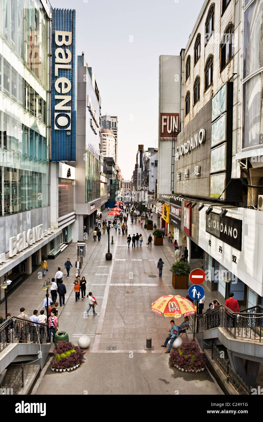 La Chine, Wuhan : scène de rue à Wuhan avec rue piétonne bondée et pont et ses boutiques internationales et McDonald's annonce. Banque D'Images