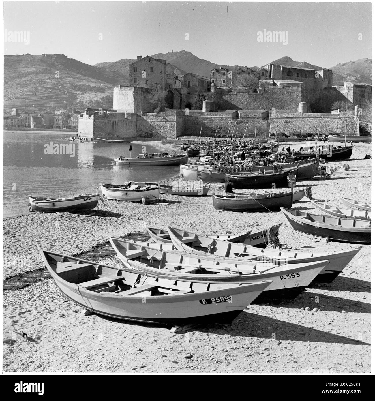 Dans les années 1950, des bateaux de pêche amarrés sur la plage par le château médiéval Royal de Collioure, dans le village côtier de Collioure, dans le sud de la France. Banque D'Images