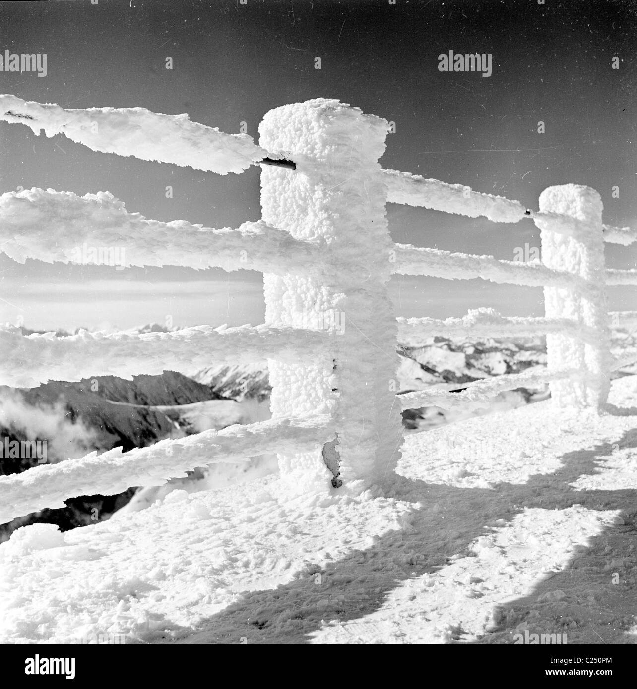 France,1950s. La neige recouvre les barrières d'une clôture de route de montagne. Banque D'Images