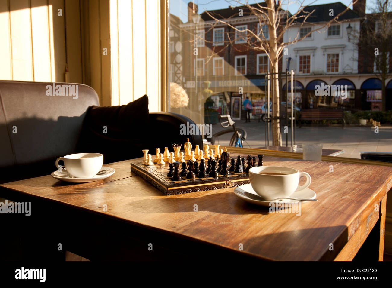 Jeu d'échecs figurant sur une table à café avec deux tasses Banque D'Images Jeu d'échecs figurant sur une table à café avec deux tasses Banque D'Images