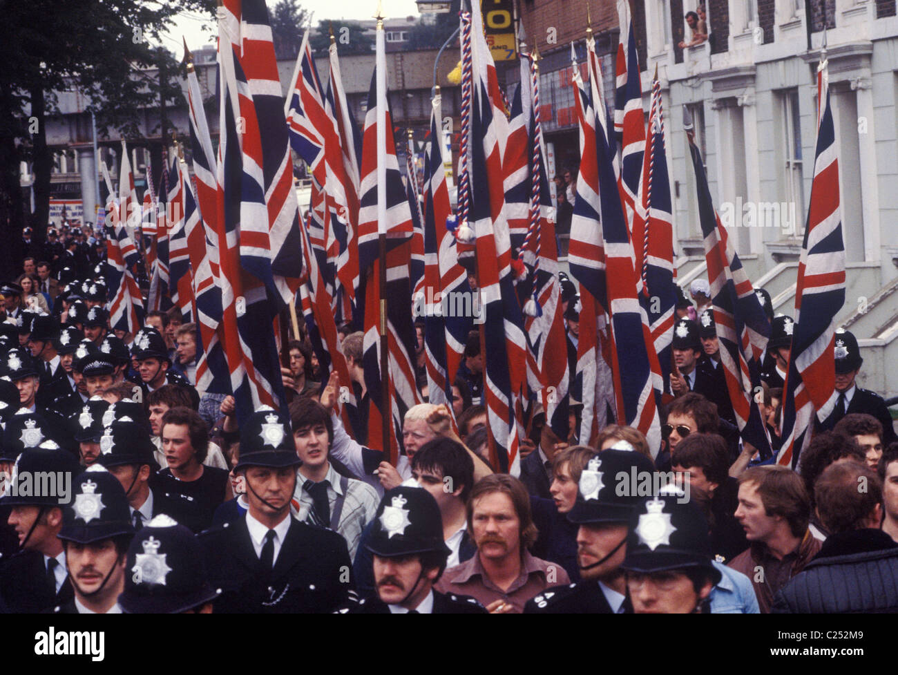 Front national marche à travers Lewisham South London Angleterre 1977. La police protège les NF alors qu'ils marchent contre les manifestants de l'ailier gauche. Les drapeaux de l'Union Jack sont portés comme un symbole de la Grande-Bretagne et de la Britishness. Les émeutes de Lewisham s'ensuivirent. 1970s Royaume-Uni. HOMER SYKES Banque D'Images