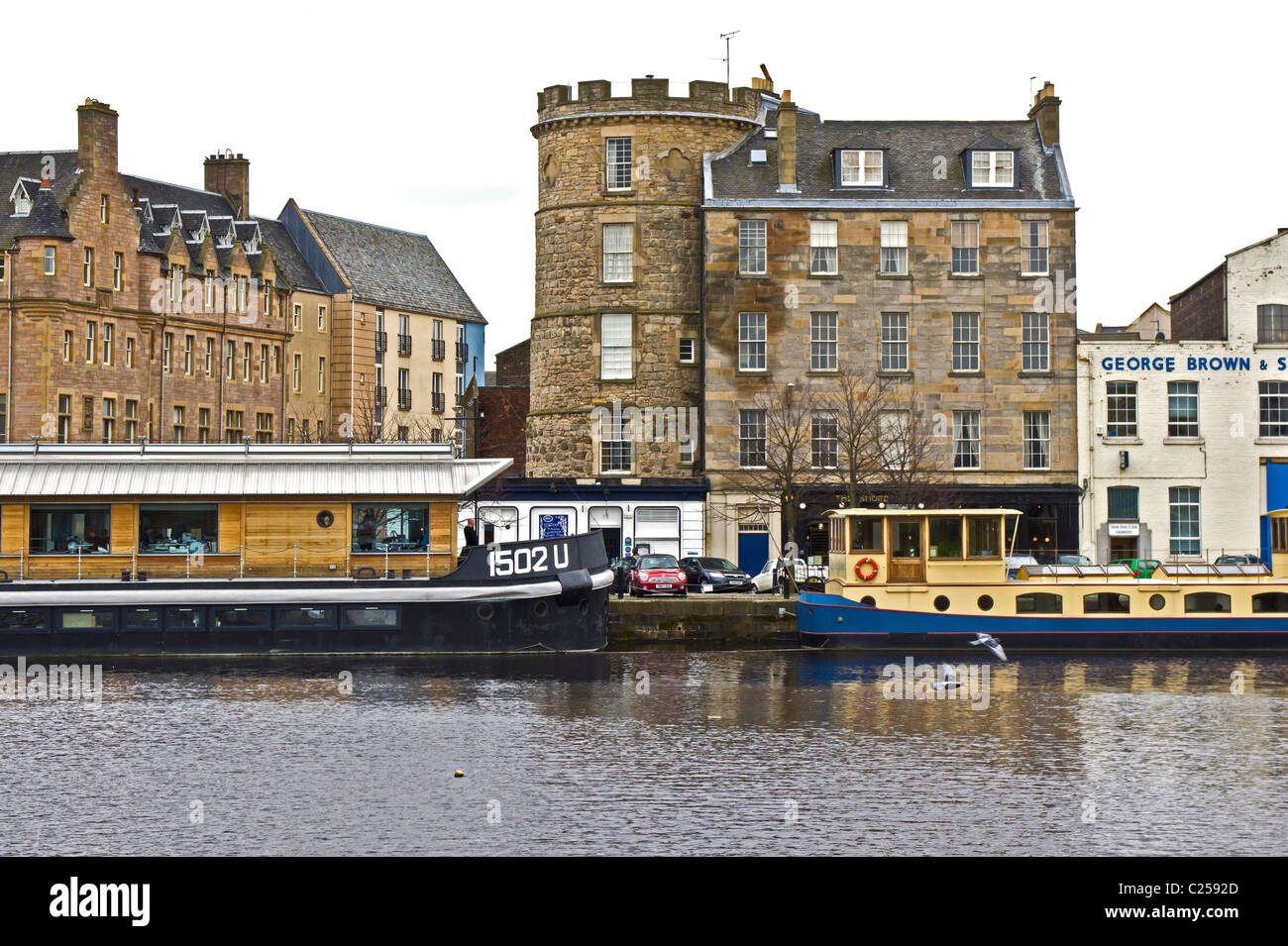 Vue de la rive au Queen's Dock de Leith Docks Edinburgh avec l'ancienne tour à signaux et les bateaux amarrés au quai Banque D'Images