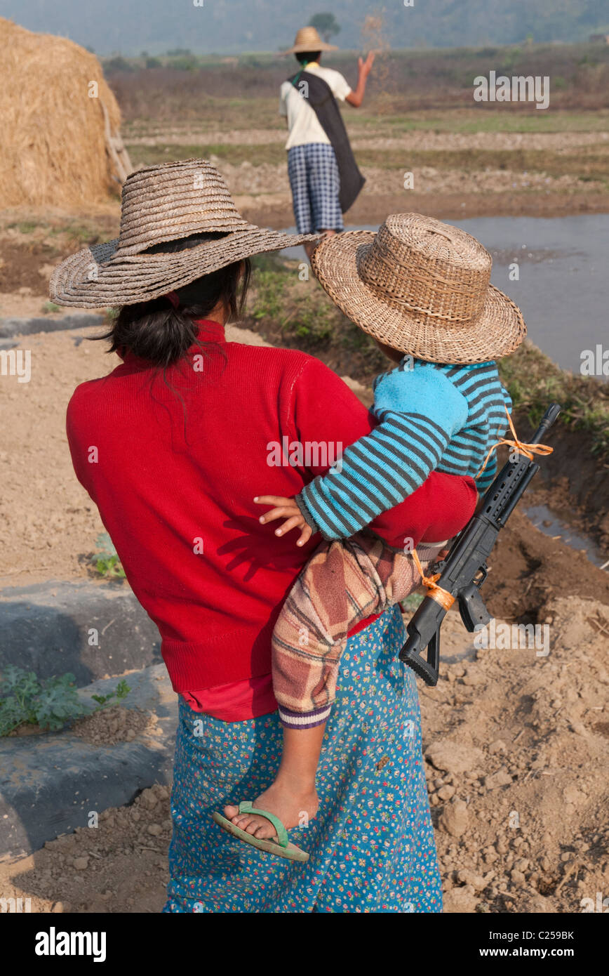 La mère et l'enfant avec pistolet jouet en champ. Hsipaw. Le nord de l'État Shan. Myanmar Banque D'Images