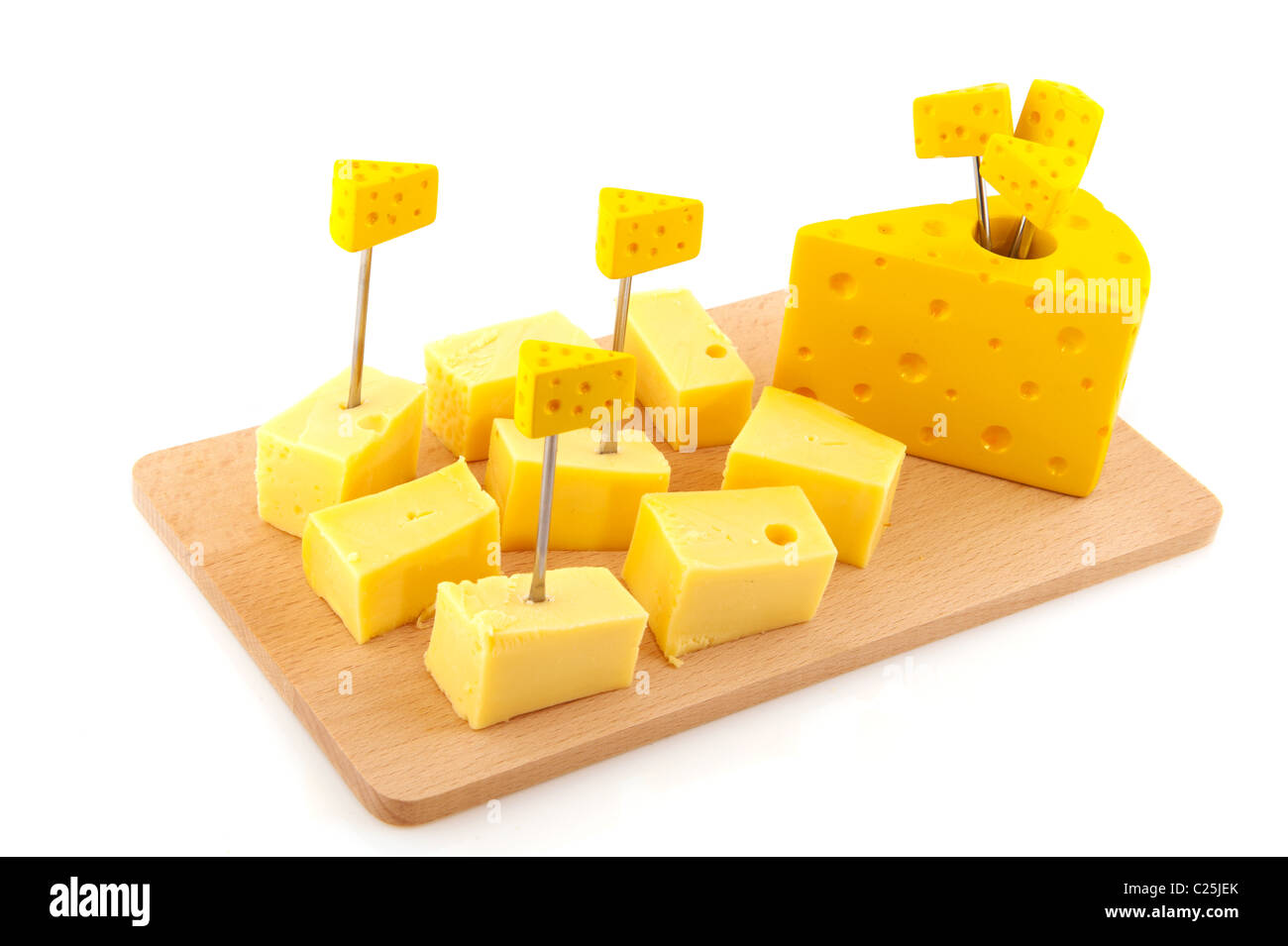 Des cubes de fromage avec picks sur une planche en bois Banque D'Images