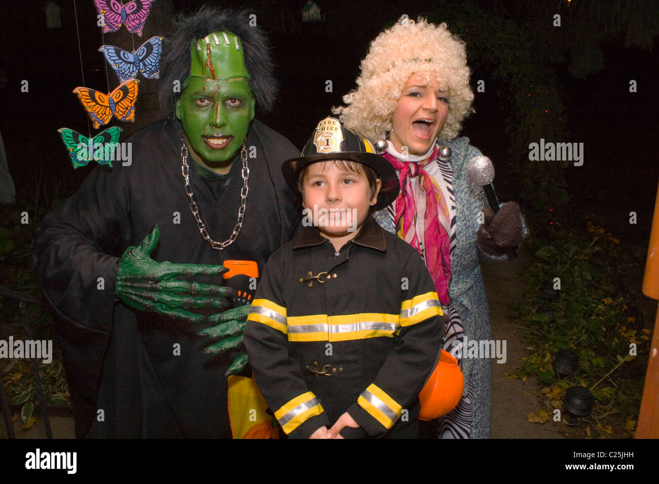Maman et papa avec fireman fils l'observation et le traitement de l'Halloween. St Paul Minnesota MN USA Banque D'Images
