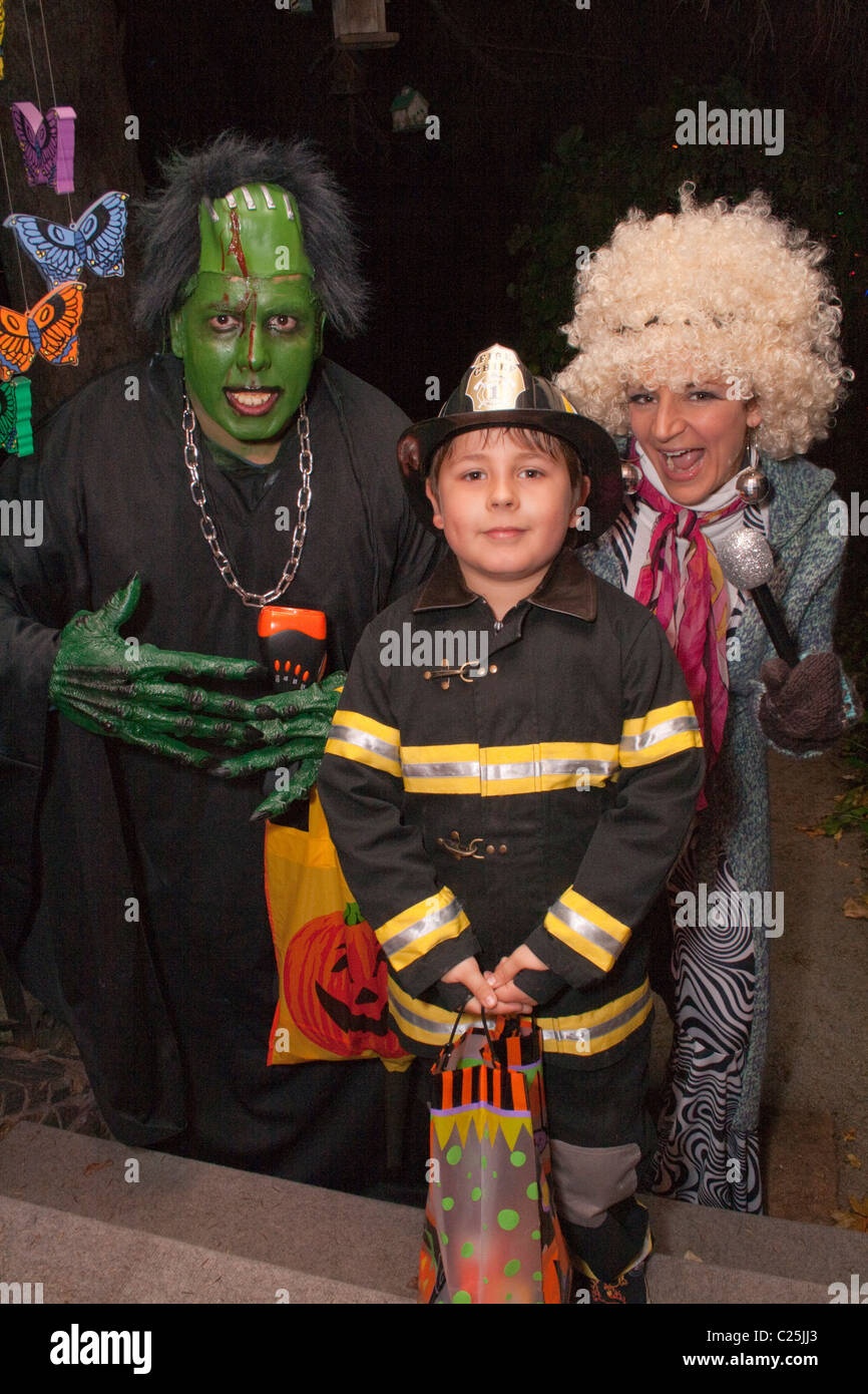 Maman et papa avec fireman fils l'observation et le traitement de l'Halloween. St Paul Minnesota MN USA Banque D'Images