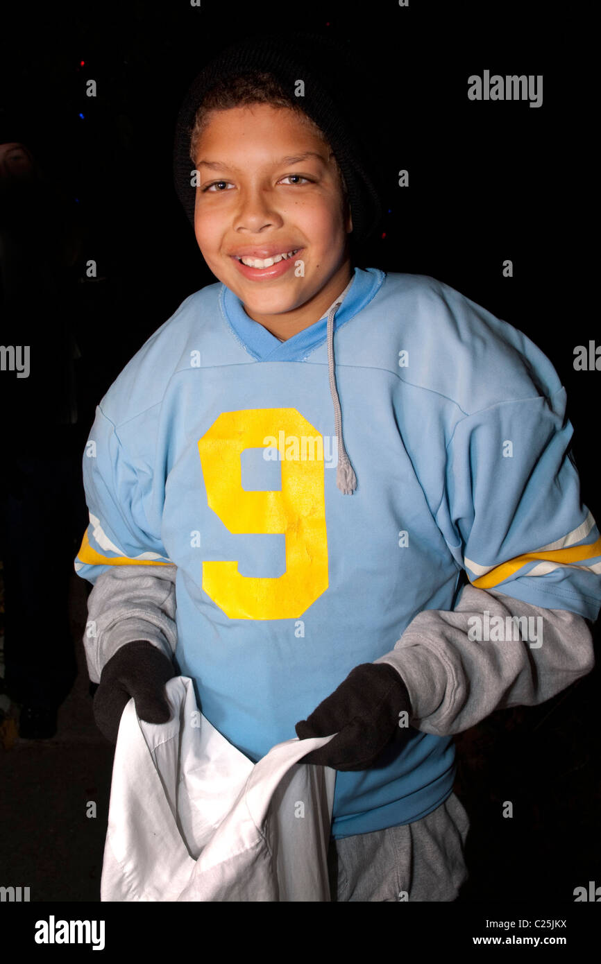 Traiteur ou halloween avec numéro 9 sweat athletic tenant son sac de bonbons. St Paul Minnesota MN USA Banque D'Images